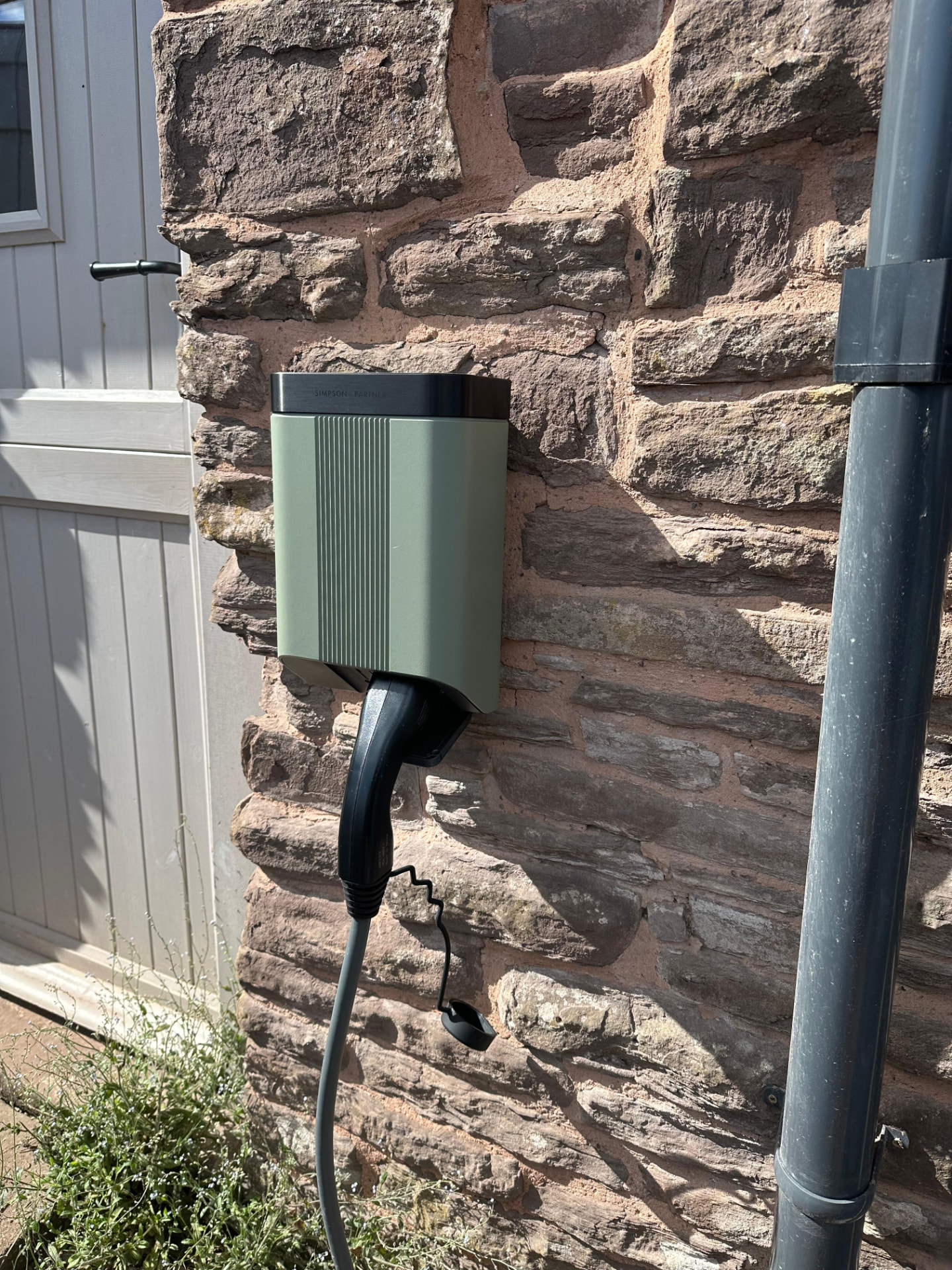 Andersen EV charger installed to a stone exterior wall for a home charge point