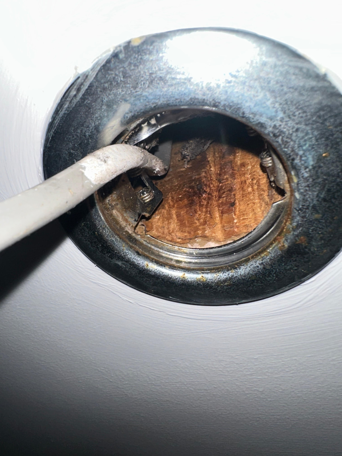 Rusted and corroded light fitting discovered in a ceiling void during inspection
