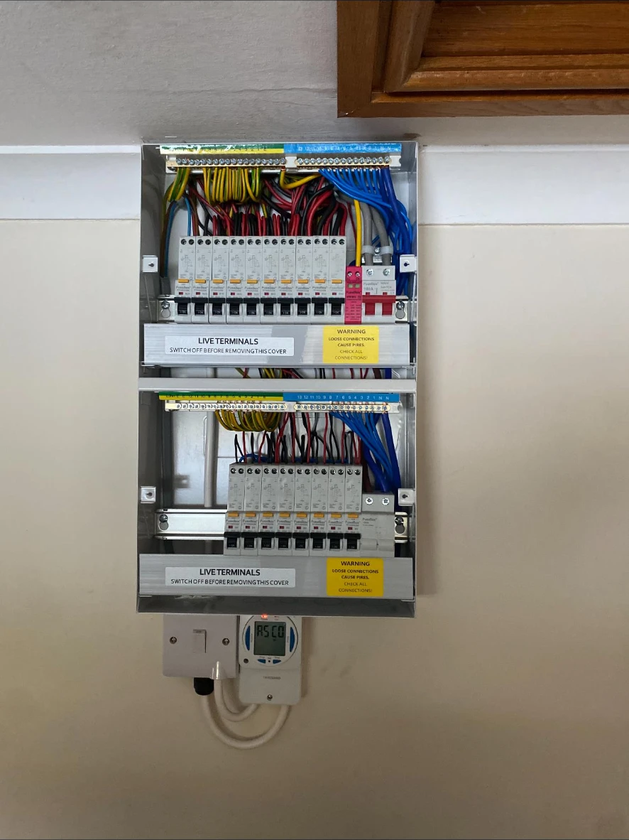 Twin FuseBox consumer units with labelled RCBOs and heating time clock installed during a fuse board upgrade