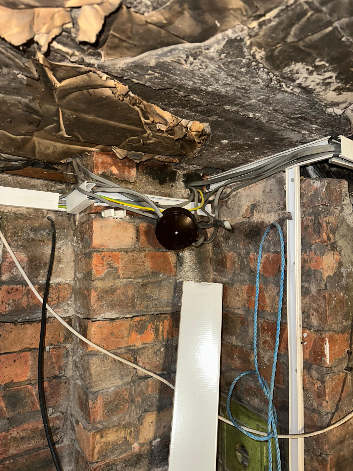 Exposed junction box and cabling on an exterior wall flagged as dangerous during EICR