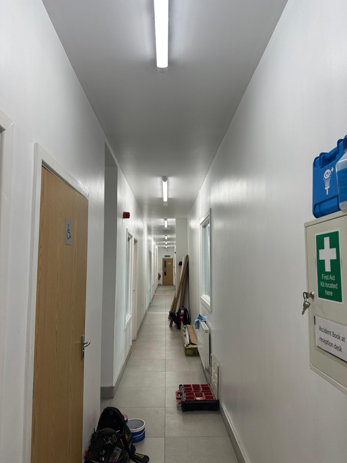 Commercial corridor with LED batten lighting installed as part of a workplace fit-out