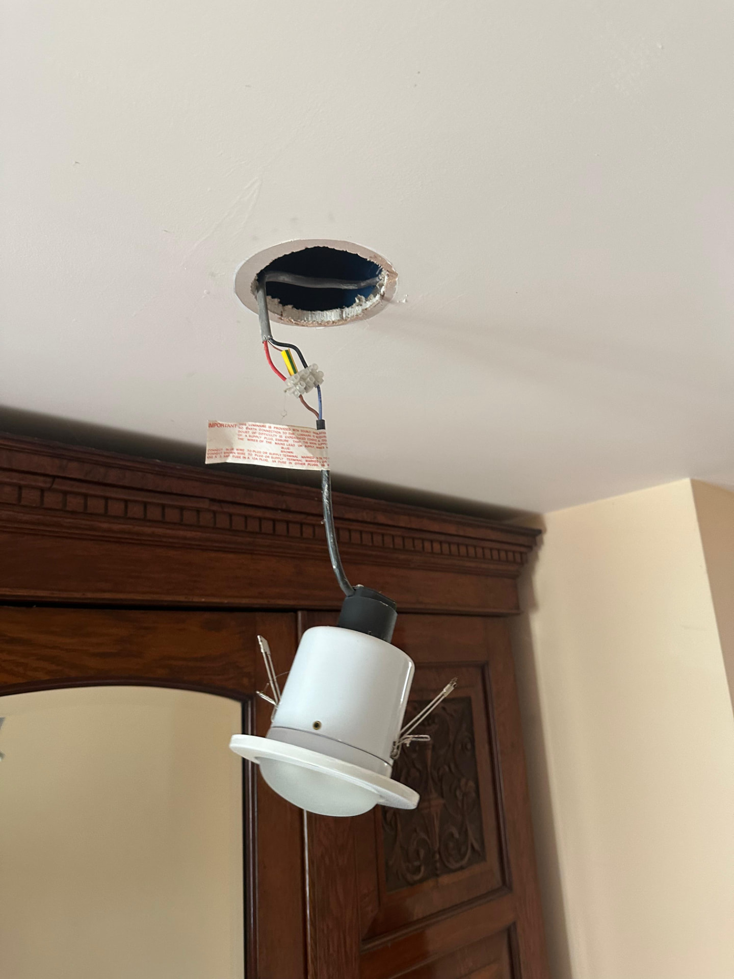 Pendant light fitting left hanging by its wires, a Category 1 fault found on EICR