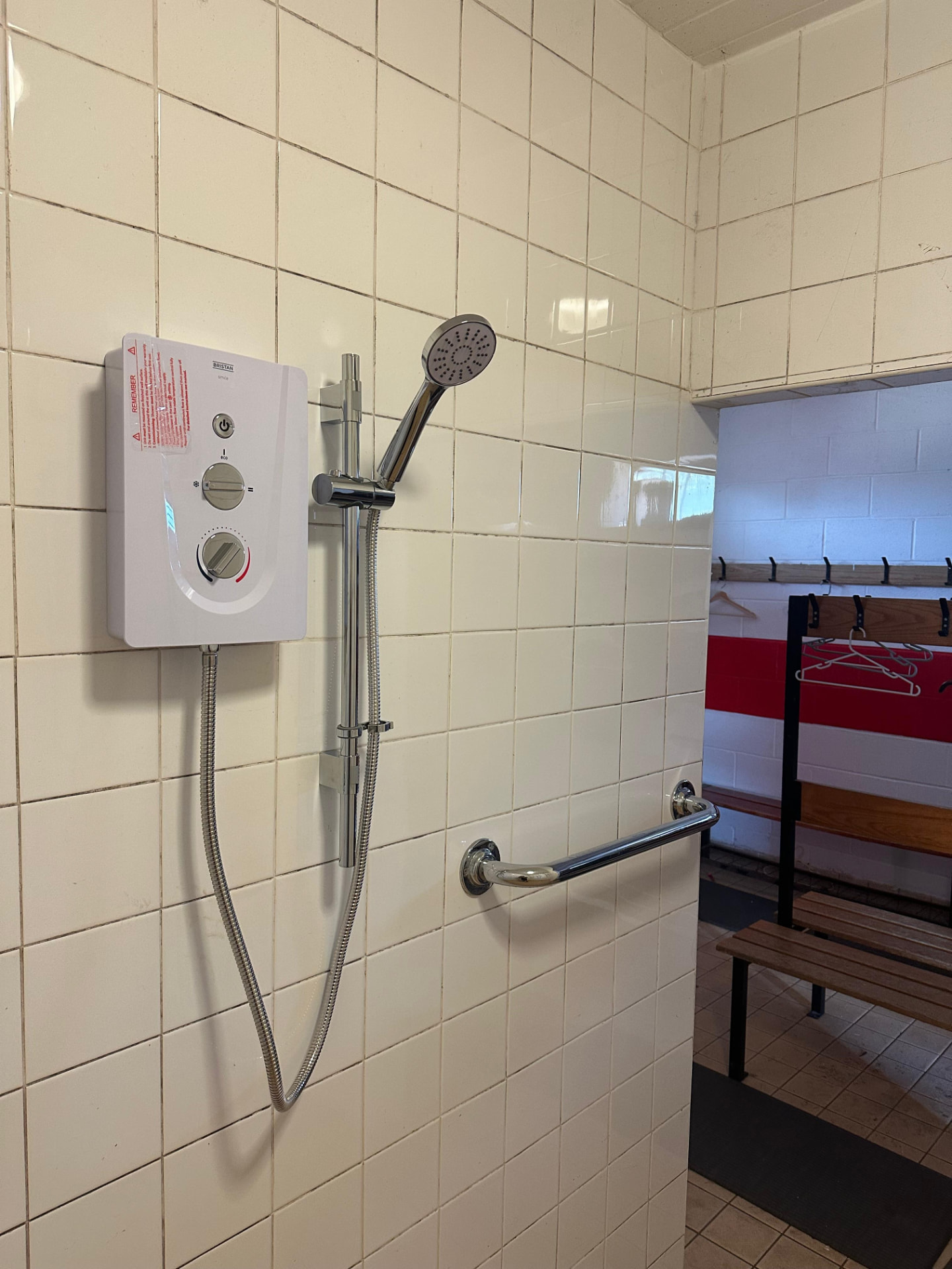 New electric shower unit installed to tiled bathroom wall to current wiring regulations